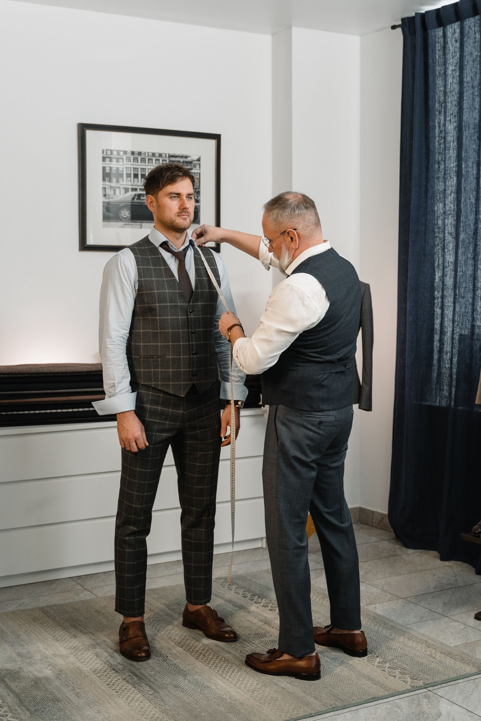 Sastre midiendo a un cliente para un traje a la medida